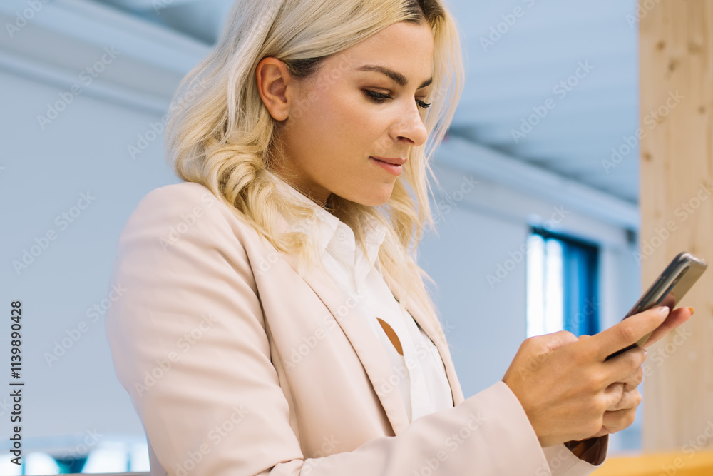 Fototapeta premium Young businesswoman using smartphone near railing