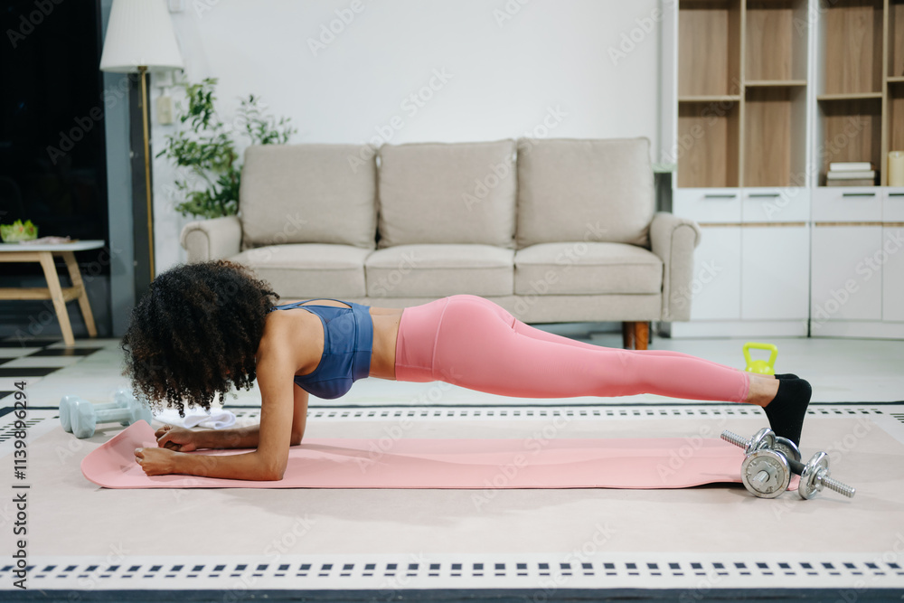 © Nuttapong punna - A young woman practices yoga and stretching with a mat and gym props, showcasing wellness, motivation,