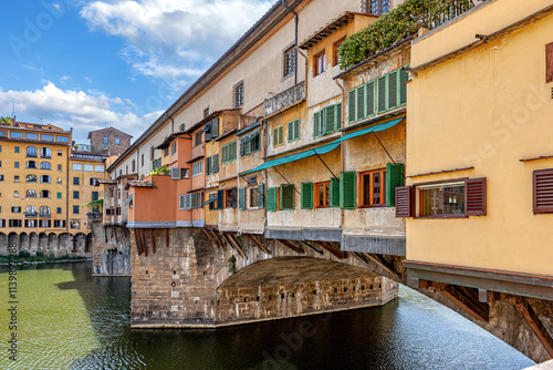 Obraz na płótnie Captivating view of Ponte Vecchio bridge with vibrant houses over the Arno River in Florence during daylight w salonie