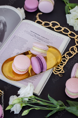 Three Purple Macarons on a Gold Stand with a Black Background, Golden Decorations and Flowers