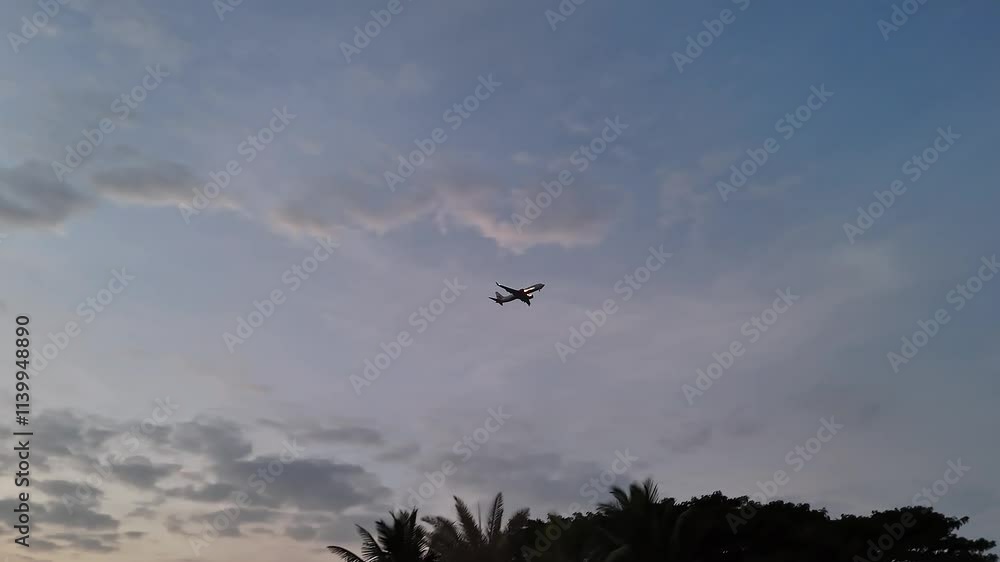 A low-angle view of a speeding airplane against a dark cloudy dusk sky approaching landing