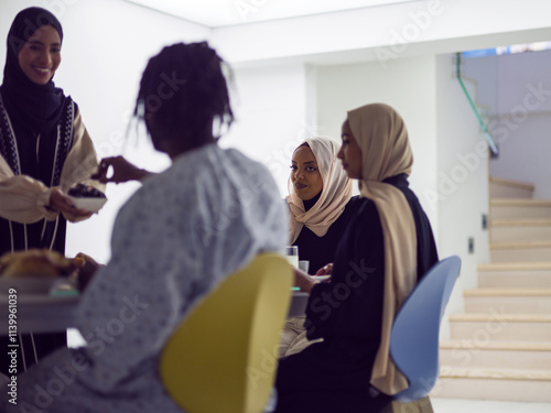 A woman in a hijab extends a platter of dates to her diverse family, creating a scene of unity and joy as they come together to break their fast during the holy month of Ramadan, symbolizing the photo