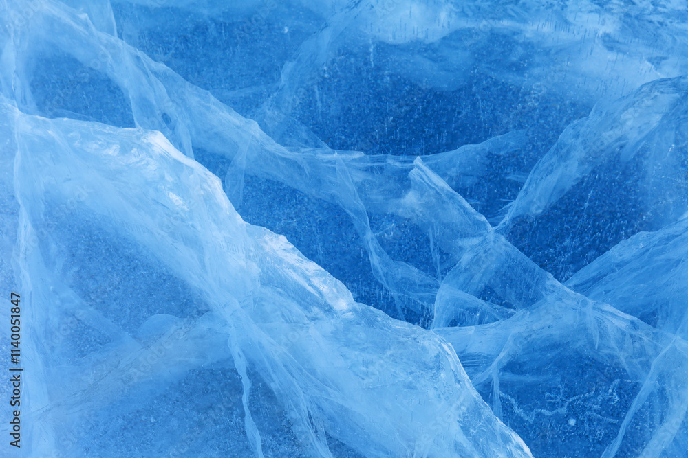 Obraz premium Beautiful crystalline ice texture. Cold background of blue ice with cracks and lines of icy surface of frozen Baikal Lake on winter. Unique ice pattern. Top view, flat lay, mockup, copy space,