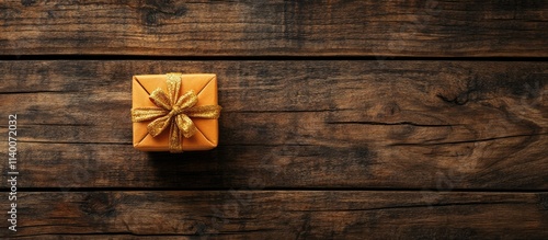 Eco-friendly Christmas gift box with dried orange and gold bow on rustic wood surface minimalistic arrangement flat lay zero waste concept photo