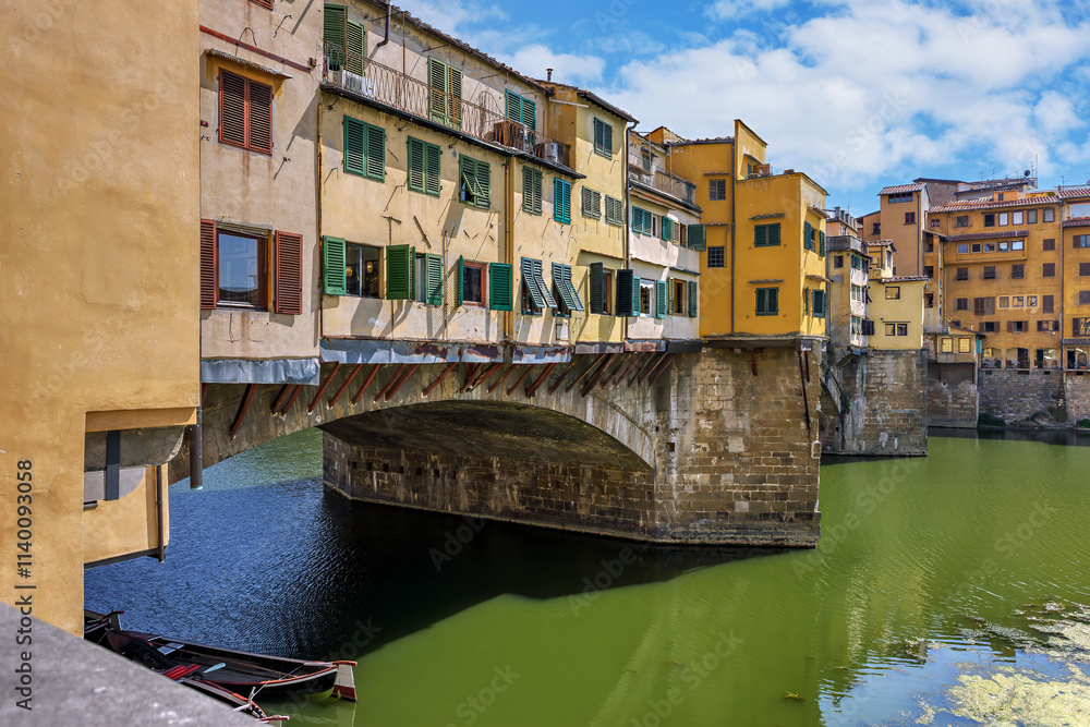 Captivating view of Ponte Vecchio bridge with vibrant houses over the Arno River in Florence during daylight