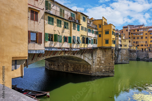 Captivating view of Ponte Vecchio bridge with vibrant houses over the Arno River in Florence during daylight