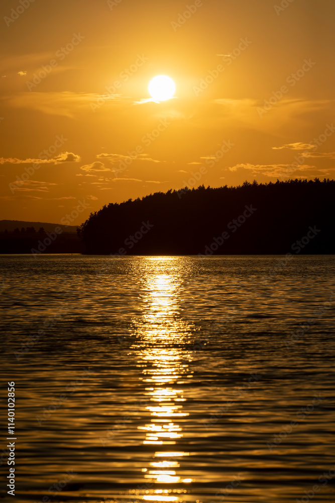 Naklejka premium orange sky during sunset on the lake
