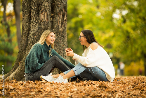 Two beautiful young women sitting in public park