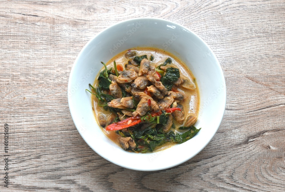 spicy boiled clam with basil in curry and coconut milk soup on bowl spicy boiled clam with basil in curry and coconut milk soup on bowl