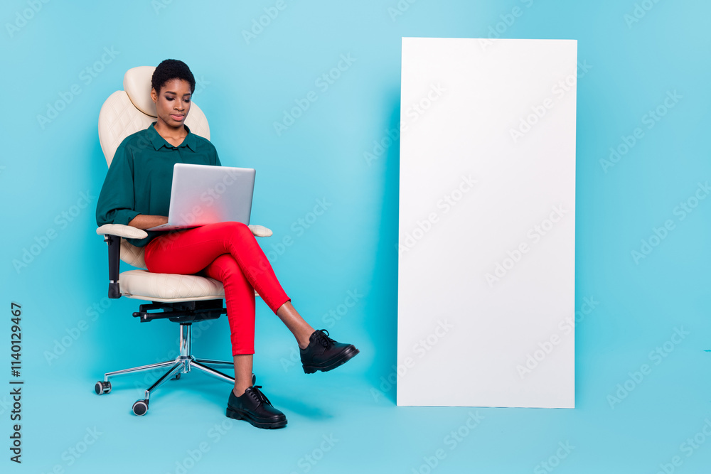 Portrait of attractive girl copy space sitting in chair using laptop ui menu panel isolated over bright blue color background Portrait of attractive girl copy space sitting in chair using laptop ui menu panel isolated over bright blue color background