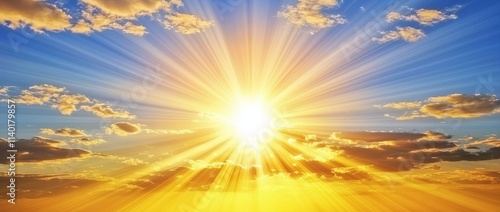 A stunning blue summer sky with a radiant sun setting in the background.