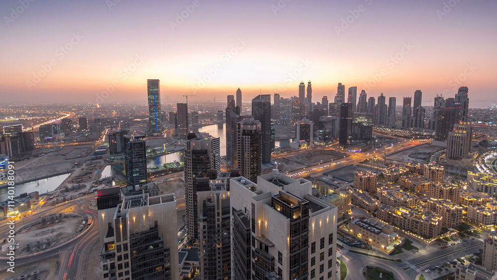 Obraz premium Aerial view of a big modern city day to night timelapse. Business bay, Dubai, United Arab Emirates.