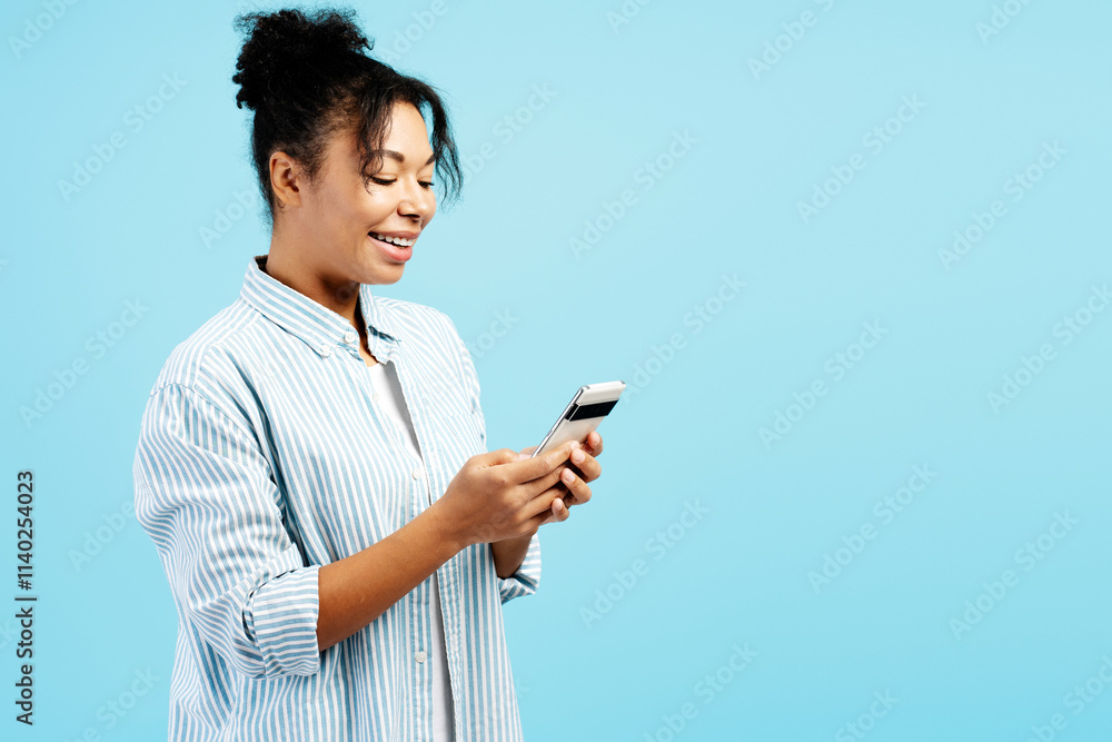 Cheerful young woman using mobile phone on blue background Cheerful young woman using mobile phone on blue background