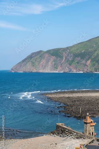 High angle view of harbor and beaches of Lynmouth, UK with iconic Rhenish Tower and sea and coastline in background photo