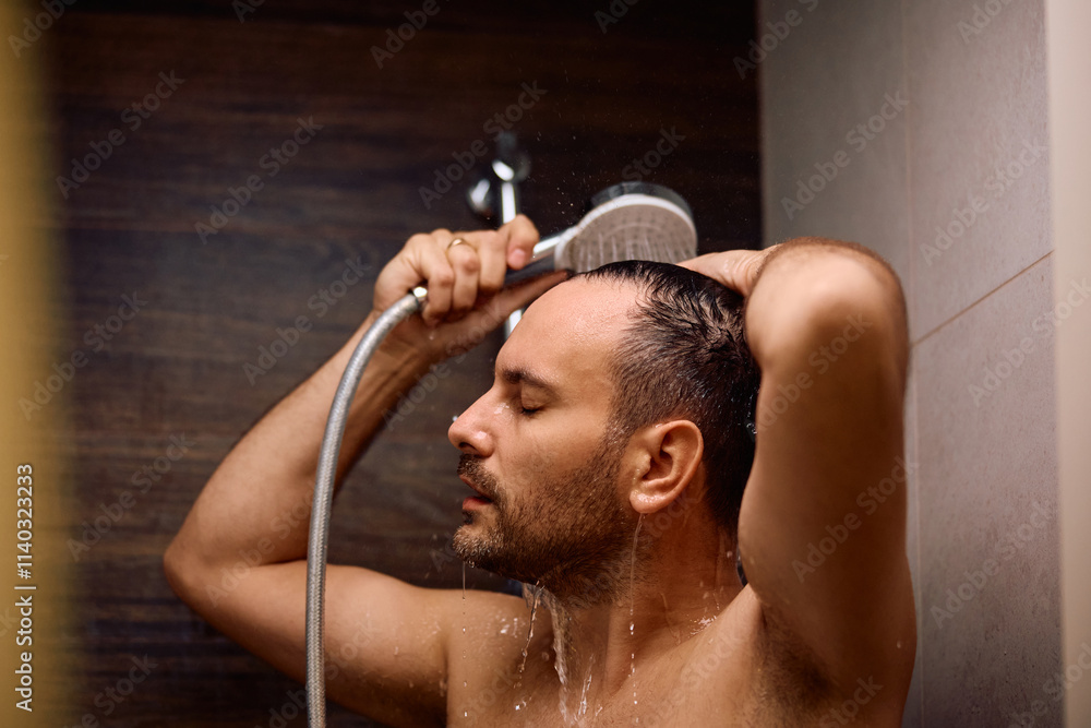 Man with eyes closed showering in bathroom. Man with eyes closed showering in bathroom.