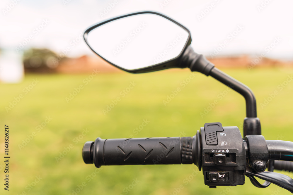 Black motorcycle rearview mirror and motorcycle handlebar on a sunny day of travel Black motorcycle rearview mirror and motorcycle handlebar on a sunny day of travel