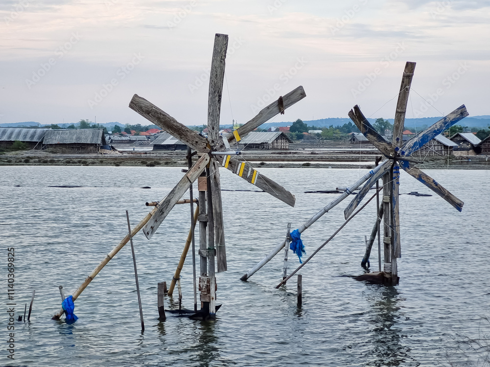 The windmills in traditional salt ponds to regulate the flow of irrigation water in Indonesia The windmills in traditional salt ponds to regulate the flow of irrigation water in Indonesia