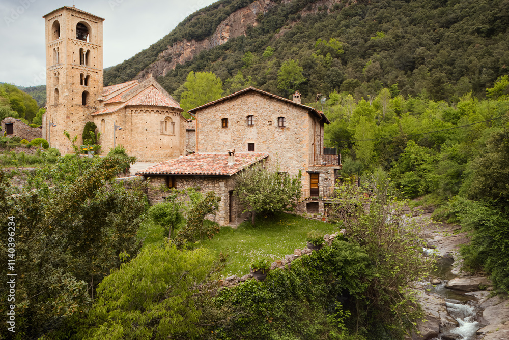 Scenic View of Medieval Stone Buildings and Church in Beget, Girona Surrounded by Lush Greenery and Mountains Scenic View of Medieval Stone Buildings and Church in Beget, Girona Surrounded by Lush Greenery and Mountains