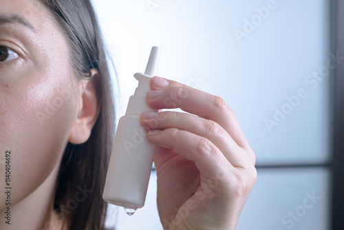 Woman holding an ear cleaning spray, instructions for cleaning ear canals and removing earwax, personal hygiene and ear care. photo