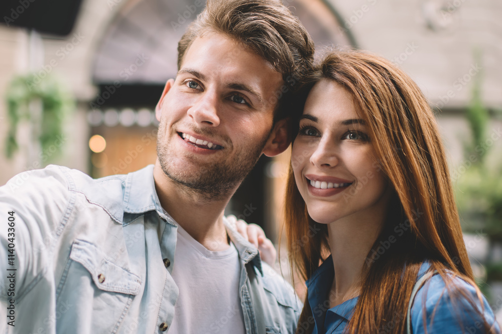 Happy couple taking selfie with smartphone on street