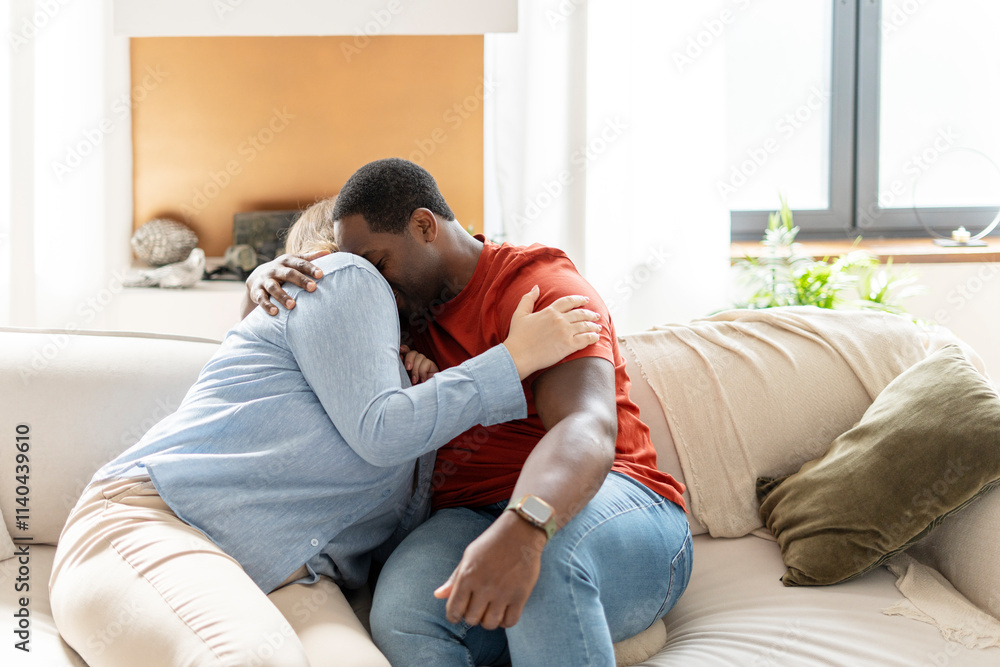 Happy couple relaxing on the couch at home in the living room and hugging Happy couple relaxing on the couch at home in the living room and hugging