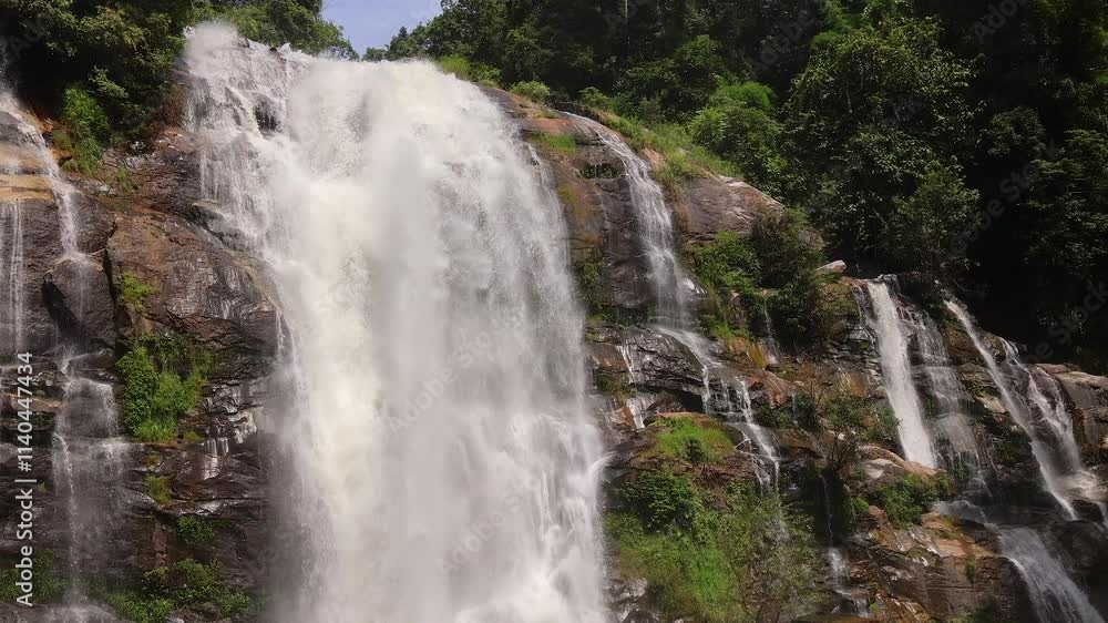 Waterfall Cascading Over Rugged and Rocky Terrain Surrounded by Natures Beauty. Waterfall Cascading Over Rugged and Rocky Terrain Surrounded by Natures Beauty.