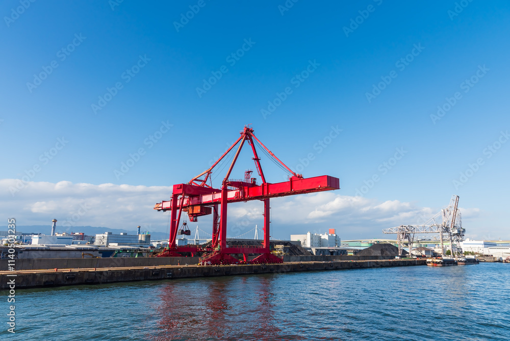 Obraz premium Container port and container crane at Industrial port for cargo container ship Osaka Japan. Business logistic transportation concept.