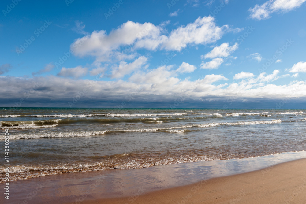 Under both blue skies and distant clouds, the waves of Lake Michigan wash onshore at Harrington Beach State Park, Belgium, Wisconsin in mid-November Under both blue skies and distant clouds, the waves of Lake Michigan wash onshore at Harrington Beach State Park, Belgium, Wisconsin in mid-November