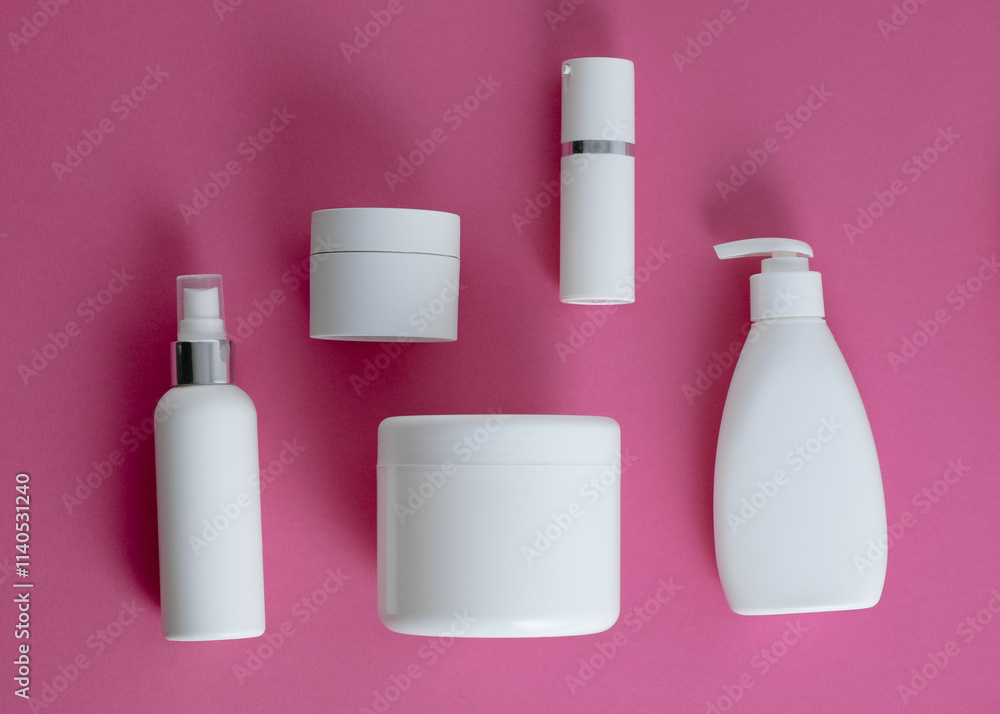 Cosmetic bottles for skincare, hair, and body care on a pink-gray background Cosmetic bottles for skincare, hair, and body care on a pink-gray background