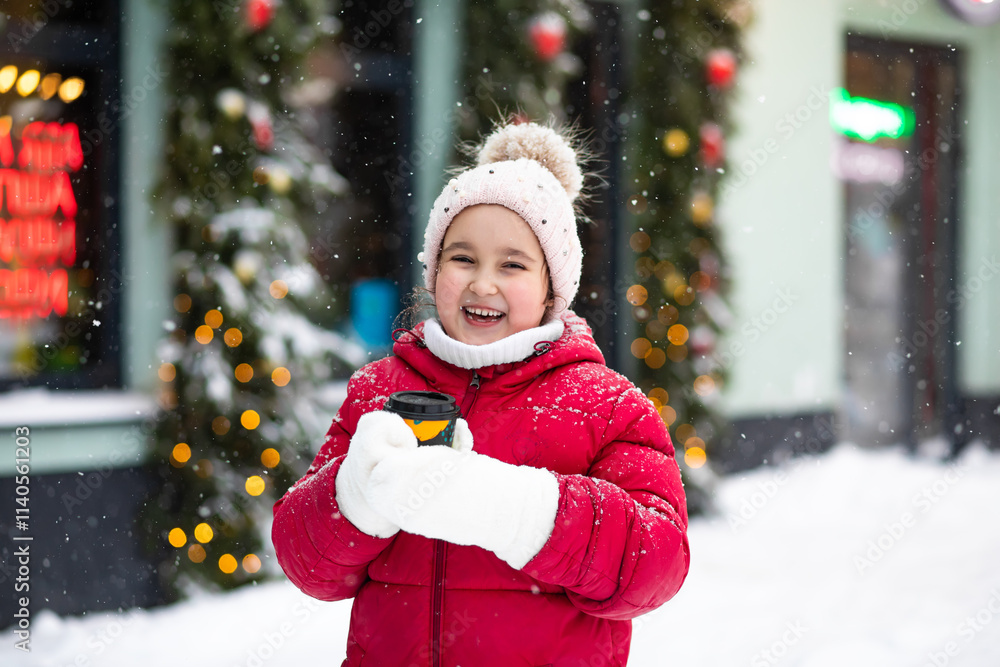 Cute little girl kid child with a paper cup of hot cocoa or tea in winter on the background of the snow city Cute little girl kid child with a paper cup of hot cocoa or tea in winter on the background of the snow city