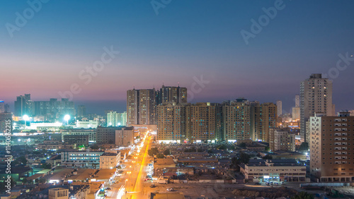 Cityscape with towers in Ajman from rooftop day to night timelapse. United Arab Emirates. photo