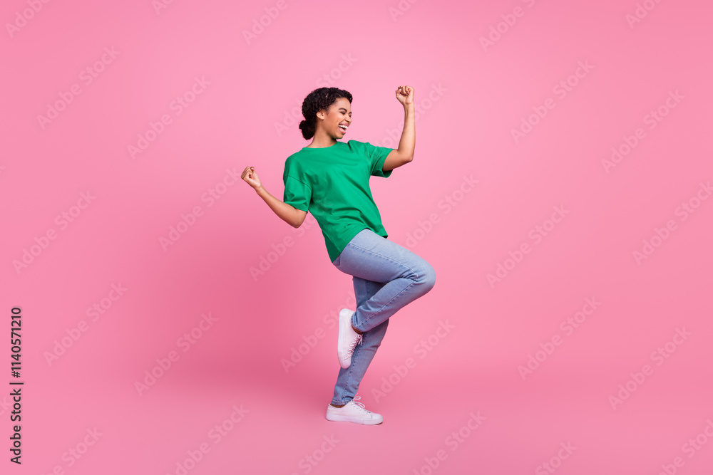 Full size photo of pretty young girl winning celebrate wear trendy green outfit isolated on pink color background Full size photo of pretty young girl winning celebrate wear trendy green outfit isolated on pink color background