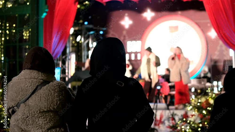 from the back, people watching a concert on the street in winter from the back, people watching a concert on the street in winter