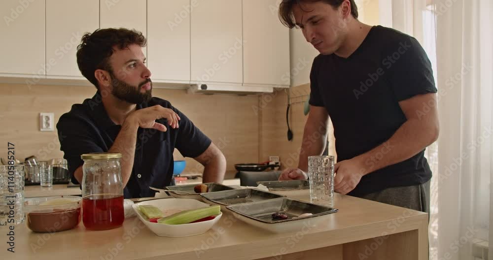 Two Caucasian men enjoy a healthy breakfast together in their modern kitchen. They share a laugh and conversation, creating a heartwarming scene of friendship and connection. Two Caucasian men enjoy a healthy breakfast together in their modern kitchen. They share a laugh and conversation, creating a heartwarming scene of friendship and connection.