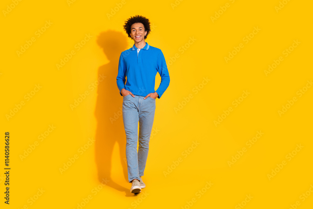 Full body photo of attractive young man posing model walking dressed stylish blue clothes isolated on yellow color background
