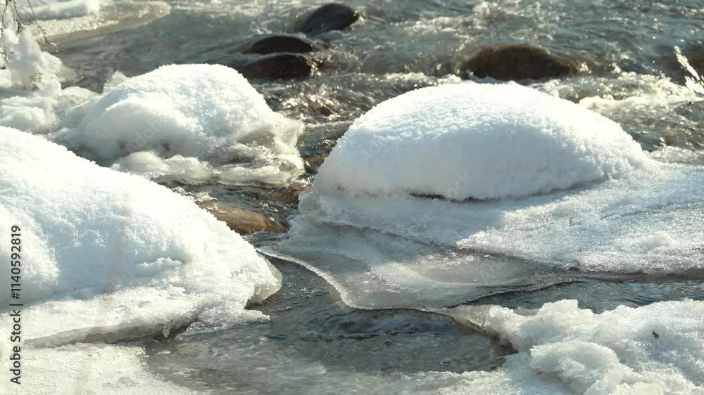 A river with a rapid flow in a mountainous area with different vegetation and houses. Winter time. A river with a rapid flow in a mountainous area with different vegetation and houses. Winter time.