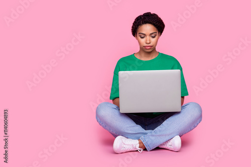 Full size photo of pretty young girl sit floor work netbook wear trendy green outfit isolated on pink color background
