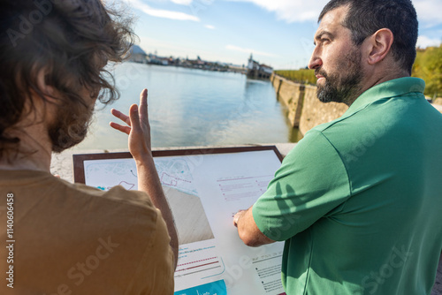 Man guides friend along scenic waterfront, fostering connection photo