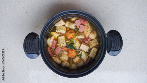 A bowl of soup with vegetables and meat in it.