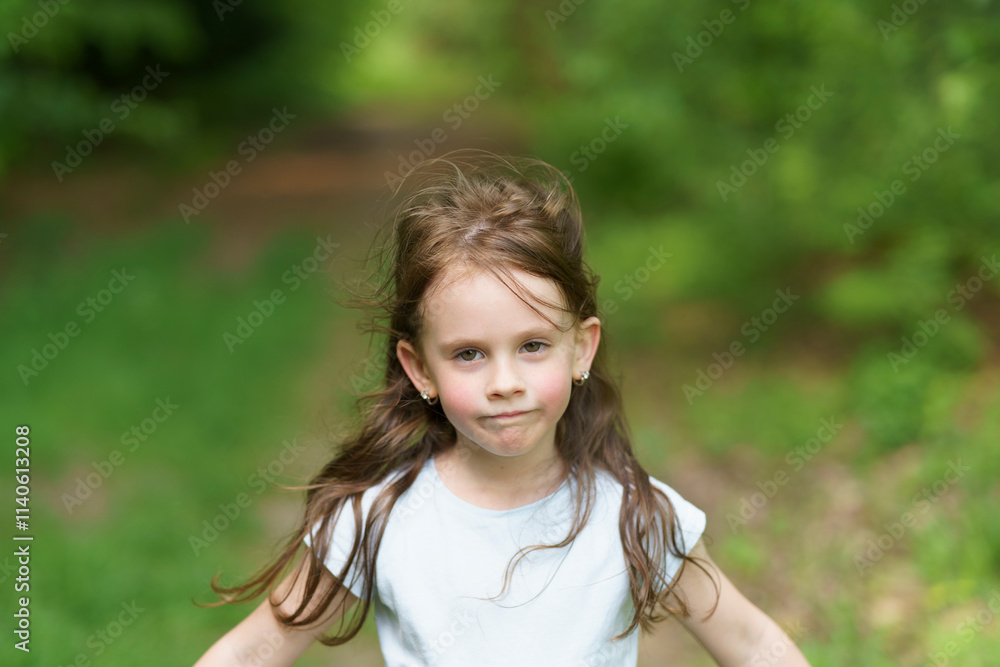 Sad girl in a T-shirt and denim shorts on a dirt path in a summer forest. Concept of a tired healthy active child Sad girl in a T-shirt and denim shorts on a dirt path in a summer forest. Concept of a tired healthy active child
