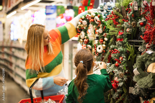 Family mom and daughter shopping Christmas presents and decoration in shopping mall