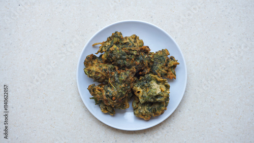A plate of fried bakwan made from spinach with green color