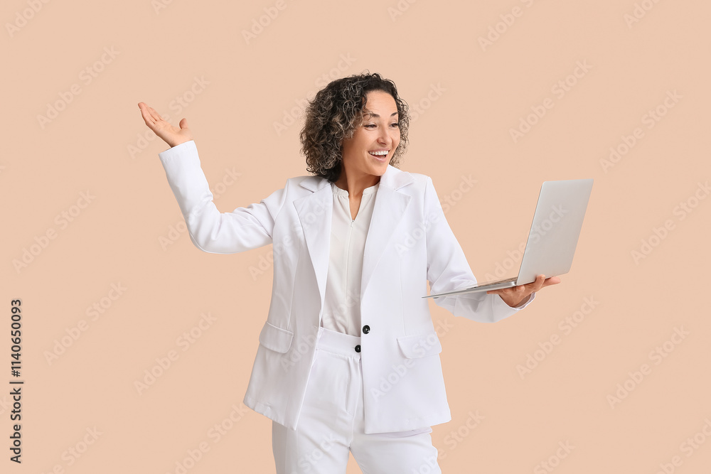 Mature businesswoman with modern laptop on beige background Mature businesswoman with modern laptop on beige background