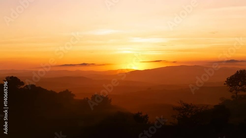 Wallpaper Mural Sun rising over a mountain range, casting golden light and long shadows on the landscape. Torontodigital.ca