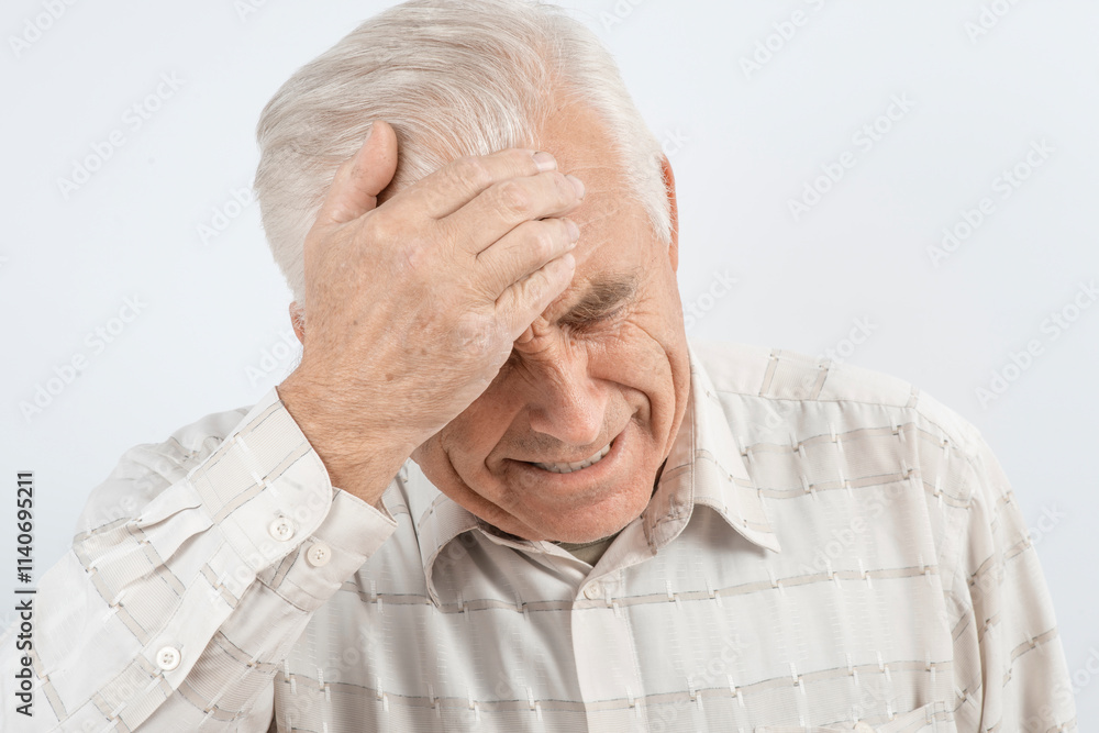 Mature man clutching his head with his hands. Older man suffers from headache, forgetfulness, memory problems. Mature man clutching his head with his hands. Older man suffers from headache, forgetfulness, memory problems.