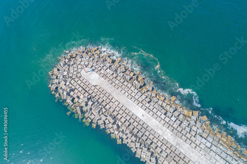 Coastal breakwater for the protection of a harbor, aerial zenithal view with a drone photo