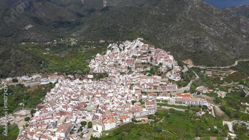 Aerial view of Ojen Village. Situated in South of Spain, Andalucia. Tipicaly spanish village with whie houses, on top of the hills. Famous travel destination. Drone going forward above the village photo