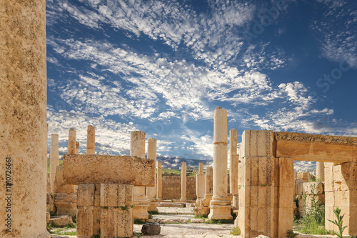 Roman ruins (against the background of a beautiful sky with clouds) in the Jordanian city of Jerash (Gerasa of Antiquity), capital and largest city of Jerash Governorate, Jordan #1140726661