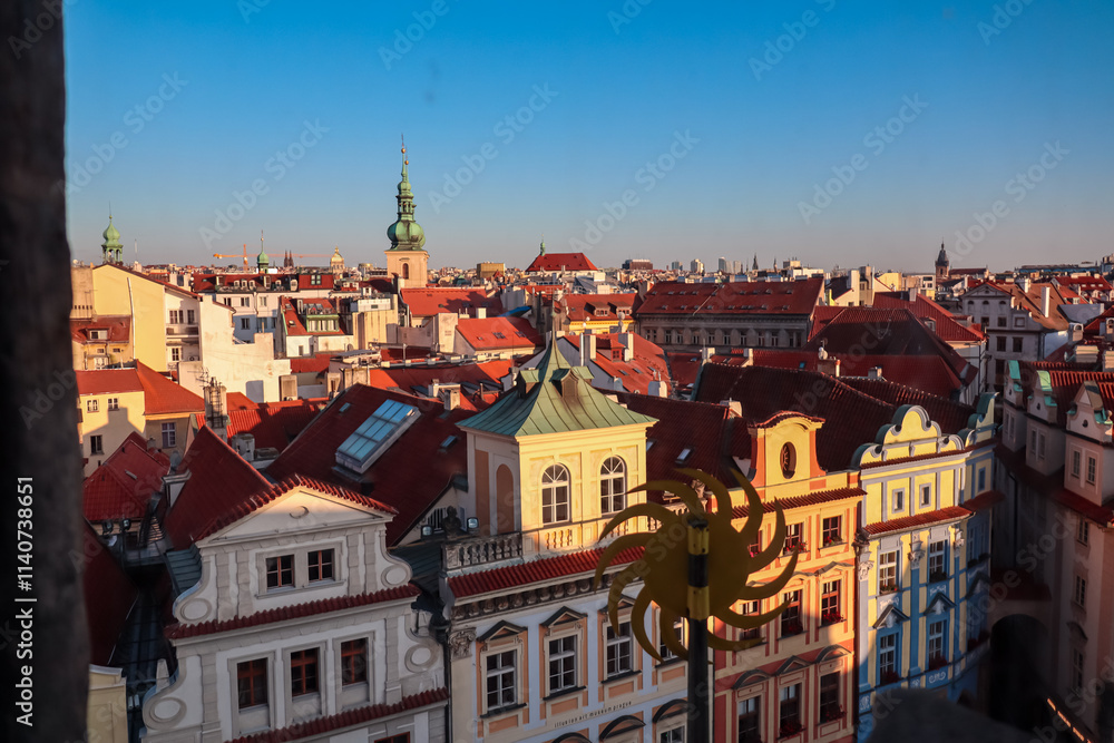 Rooftop view of Prague's Old Town. Red-tiled roofs of historic buildings create vibrant and charming cityscape. In distance, the spires and towers of churches and cathedrals rise above the skyline Rooftop view of Prague's Old Town. Red-tiled roofs of historic buildings create vibrant and charming cityscape. In distance, the spires and towers of churches and cathedrals rise above the skyline
