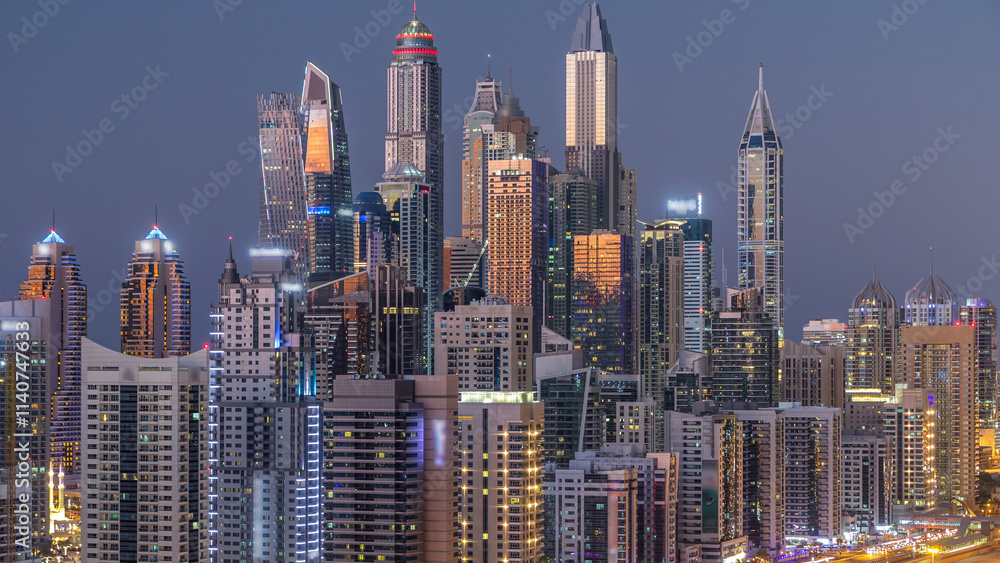 Naklejka premium Dubai marina with traffic on sheikh zayed road panorama day to night timelapse lights turn on.